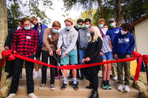 Students gather together and cut the ribbon, unveiling the new science center.